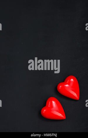 rote Herzen auf dem schwarzen Tisch Stockfoto