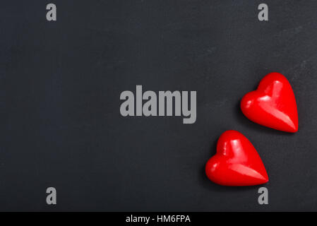 rote Herzen auf dem schwarzen Tisch Stockfoto