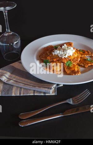 Gefüllte Pasta auf weiße Schüssel mit Serviette und schwarzem Hintergrund Stockfoto