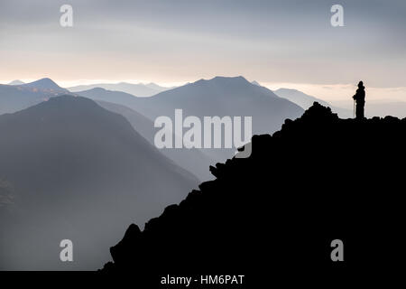 Hillwalker auf Buchaille Etive Beag in den schottischen Highlands, dunstigen Berge zurück in Ferne Stockfoto