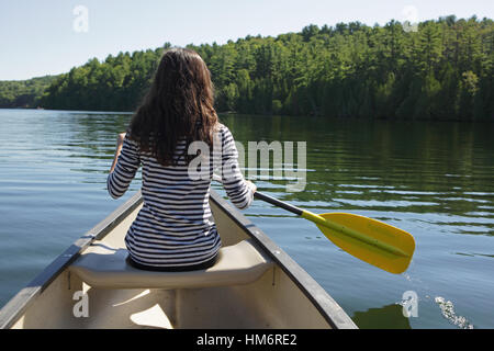 Mädchen, Kanu paddeln, auf einem ruhigen Sommer-See in der Landschaft von Vermont Stockfoto