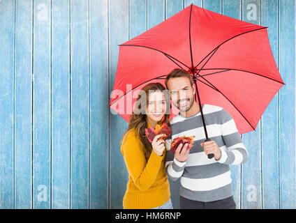 Zusammengesetztes Bild des glücklichen Paares mit Regenschirm Stockfoto