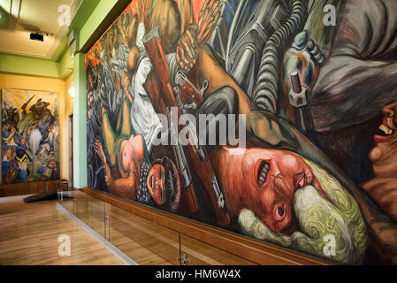 MEXIKO-STADT, Mexiko - Ein Wandgemälde von Jose Clemente Orozco aus dem Jahr 1934-35 mit dem Titel „Catharsis“ (Katharsis). Der Palacio de Bellas Artes beherbergt Mexikos Nationaltheater. Mit einem Äußeren, das eine Mischung aus Neo Classicical und Art Nouveau Stil ist, und einem Interieur, das Art Deco ist, gilt es weithin als das schönste Gebäude in Mexiko-Stadt. Sie stammt aus dem frühen 20. Jahrhundert und befindet sich im historischen Viertel Centro von Mexiko-Stadt, das zum UNESCO-Weltkulturerbe gehört. Stockfoto