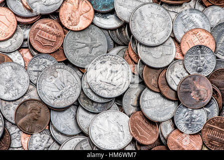 American Coins Quarters Dimes Pennnies United States // UNITED STATES — Ein verstreuter Stapel amerikanischer Münzen, darunter Quarter, Dimes, Nickels und Pennnies, zeigt die Vielfalt der US-Münzen im Umlauf. Die Viertel (25¢) weisen ihre markante Schilfkante und silberfarbene Cupronickel-Zusammensetzung auf, während kleinere Dimmen (10¢) eine ähnliche Färbung aufweisen, aber die Schilfkante fehlt. Kupferfarbene Pfennige (1¢) stehen im Kontrast zu den größeren nickelfarbenen fünf-Cent-Stücken und schaffen so eine vielfältige Palette von Stückelungen, die für den typischen Taschenwechsel im amerikanischen täglichen Handel stehen. Stockfoto