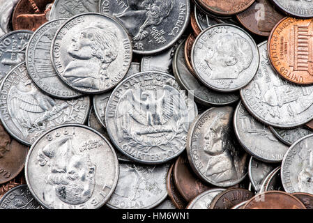 US-amerikanische Münzen Staufen Quarter Dimes Pennnies Vereinigte Staaten // VEREINIGTE STAATEN — Ein verstreuter Stapel amerikanischer Münzen, darunter Quarter, Dimes, Nickels und Pennnies, zeigt die Vielfalt der US-Münzen im Umlauf. Die Viertel (25¢) weisen ihre markante Schilfkante und silberfarbene Cupronickel-Zusammensetzung auf, während kleinere Dimmen (10¢) eine ähnliche Färbung aufweisen, aber die Schilfkante fehlt. Kupferfarbene Pfennige (1¢) stehen im Kontrast zu den größeren nickelfarbenen fünf-Cent-Stücken und schaffen so eine vielfältige Palette von Stückelungen, die für den typischen Taschenwechsel im amerikanischen täglichen Handel stehen. Stockfoto