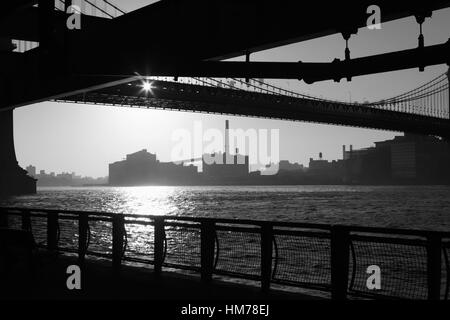 Blick vom East River Esplanade der Brooklyn Uferpromenade unter der Manhattan Bridge über den East River bei Sonnenaufgang Stockfoto