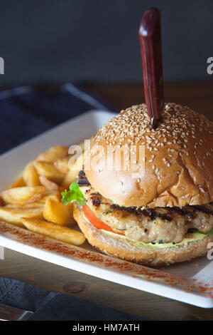 Chicken Burger hautnah mit Serviette und schwarzem Hintergrund Stockfoto