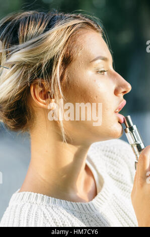 Teenager-Mädchen mit der elektronischen Zigarette Stockfoto