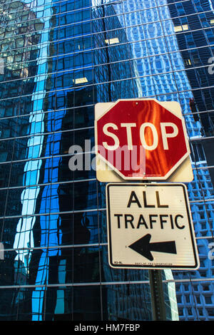 USA, New York, verzerrte Spiegelungen im Büro- und Stop-Schild vorne Stockfoto