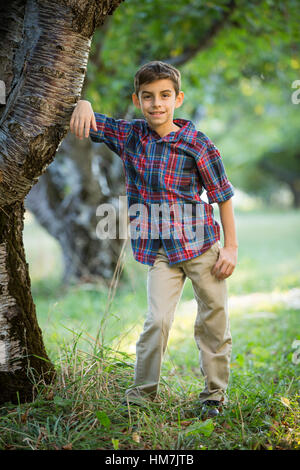 Lächelnde junge Stand von Kirschbaum Stockfoto