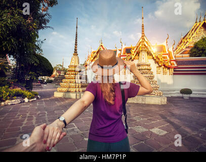 Frau in Hut und lila T-shirt Hauptdarsteller von Hand zu berühmten Tempel Wat Pho in Bangkok, Thailand. Stockfoto