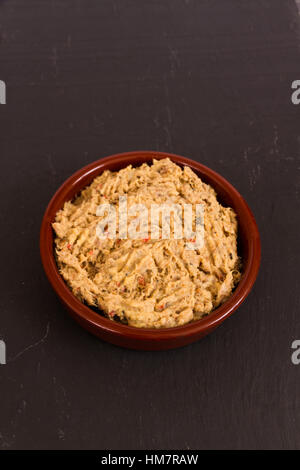 Hausgemachte geräucherte Makrele Pastete in einer Keramikscheibe auf Schiefer Hintergrund. Stockfoto