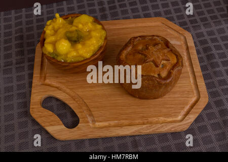 Piccalilli Relish in einer Holzschale auf einem Brett. Stockfoto