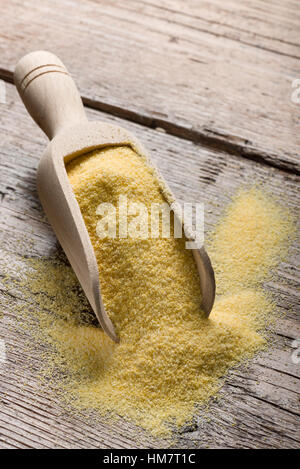 Haufen von gelbem Mehl in hölzerne Schaufel auf Tabelle. Stockfoto