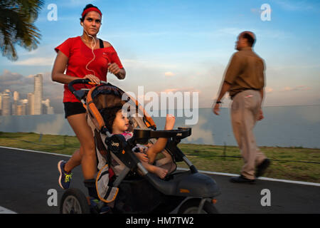 Frau mit ihrem Baby in Balboa Avenue Skyline Wolkenkratzer Straße Ufermauer neue läuft. Skyline, Panama City, Panama, Mittelamerika. Cinta Costera Pacific Stockfoto