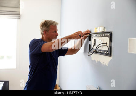 Mann, die passende Halterung für Flachbildfernseher auf Wand Stockfoto