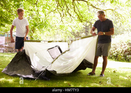 Vater und Sohn im Teenageralter Aufstellen von Zelt auf Camping-Ausflug Stockfoto