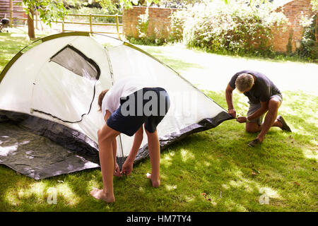 Vater und Sohn im Teenageralter Aufstellen von Zelt auf Camping-Ausflug Stockfoto