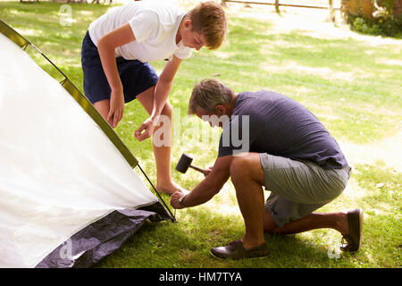 Vater und Sohn im Teenageralter Aufstellen von Zelt auf Camping-Ausflug Stockfoto