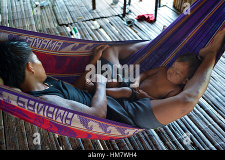 Männer und seinem Kind eine Siesta in einer Hängematte im Dorf des Stammes Native Indian Embera, Embera Dorf, Panama zu tun. Panama Embera Menschen indischen V Stockfoto