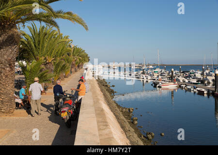 Einheimische Männer im Chat auf Palme gesäumten Promenade, Olhao, Algarve, Portugal, Europa Stockfoto