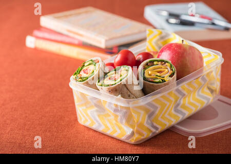 Schinken und Käse hüllt in Lunch-Box mit Apfel und Tomaten Stockfoto