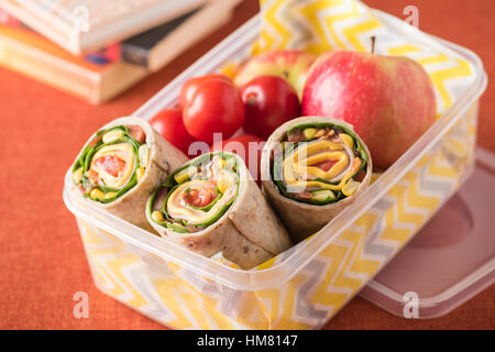 Schinken und Käse hüllt in Lunch-Box mit Apfel und Tomaten Stockfoto