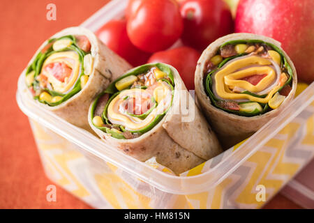 Schinken und Käse hüllt in Lunch-Box mit Apfel und Tomaten Stockfoto