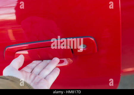 Männliche Hand Öffnen der Türgriff des rotes Auto Stockfoto