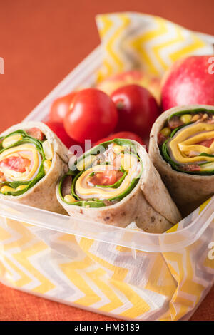 Schinken und Käse hüllt in Lunch-Box mit Apfel und Tomaten Stockfoto