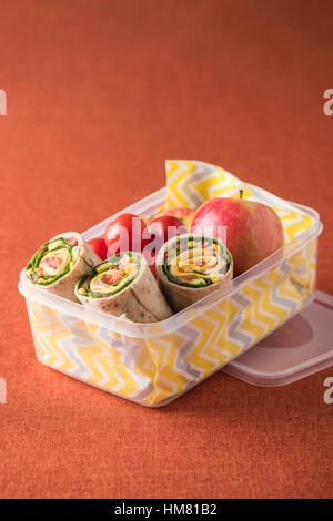 Schinken und Käse hüllt in Lunch-Box mit Apfel und Tomaten Stockfoto