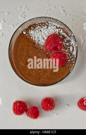 Hausgemachte Schokoladen-Mousse mit frischen Himbeeren auf einem Tisch, Seitenansicht. Stockfoto