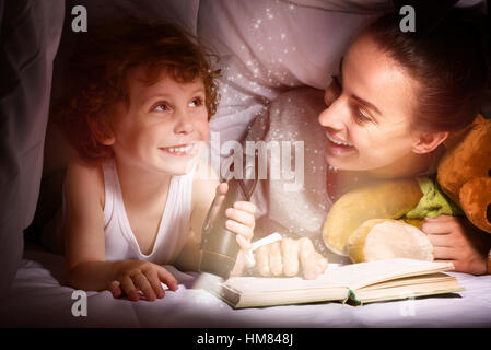 Junge Mutter ein Buch zu lesen, um ihr schönen Kind Stockfoto