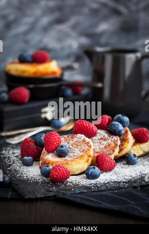 Quark-Pfannkuchen, dekoriert mit frischen Himbeeren und Heidelbeeren Stockfoto