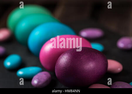 Bunt bemalte Ostereier in einem Karton auf dunklem Hintergrund Stockfoto