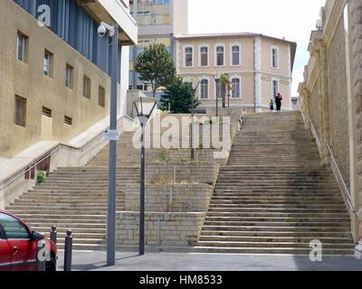 Frau Kopftuch tragen, tragen Einkaufstasche und Hand in Hand mit kleinen Jungen, absteigend sehr hoch angesetzt von Steintreppen, Marseille, Frankreich Stockfoto