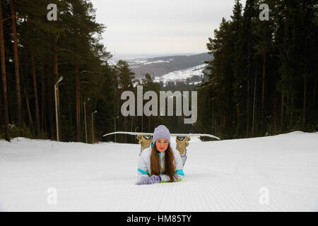 Lächelnde Frau mit Snowboarden im Skigebiet Stockfoto