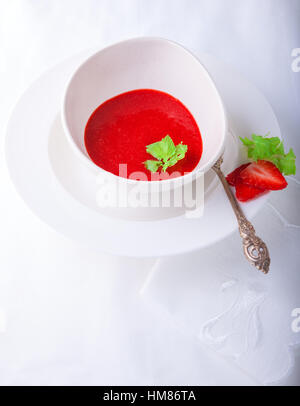Frische Erdbeer-Suppe mit Minze auf weißem Hintergrund.