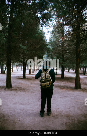 Junge Reisende mit Rucksack auf dem Weg in den Wald wandern Stockfoto