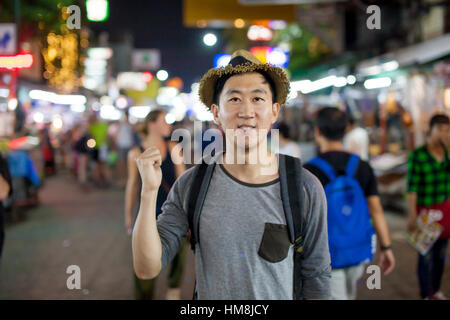 Asiatische Touristen zeigt auf der Rückseite in Asien Nachtmarkt Stockfoto