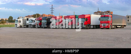 Schwere Lkw mit Anhänger beladen mit waren, stehen in einer Reihe auf eine Asphalt-Auto-Plattform. Internationaler Transport und Logistik. Road Stockfoto