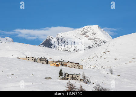 Die verschneite Hütten Rahmen Peak Tambo im Hintergrund, Andossi, Spluga Tal, Provinz Sondrio, Valtellina, Lombardei, Italien Stockfoto