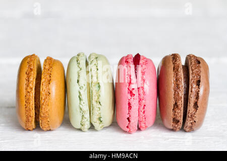 Bunte Macarons Makronen Kuchen auf weißem Holz Hintergrund closeup Stockfoto