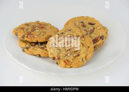 Ein Teller mit warmen, frischen Pecan Schokoladenkekse auf eine Untertasse. Nahaufnahme, drinnen. USA. Stockfoto