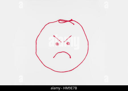 Ein wütendes Gesicht geprägt vom roten Garn. Ausschnitt. Abbildung. Konzept, konzeptionelle. Stockfoto