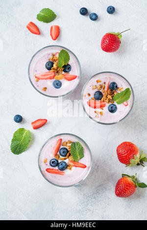 Gesunde Heidelbeeren und Erdbeeren Smoothies, garniert mit frischen Beeren Müsli und Minze Blatt mit cocktail-Rohr Stockfoto