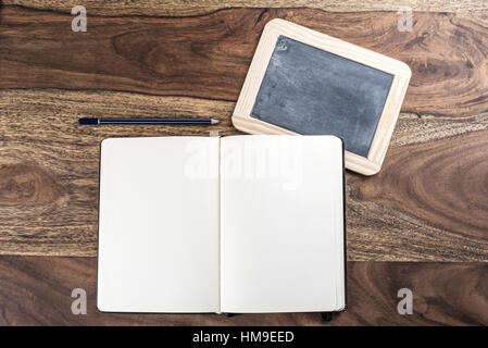 Öffnen Sie einfach leere Seite Notizbuch mit Stift und Tafel auf rustikalen Holztisch Stockfoto