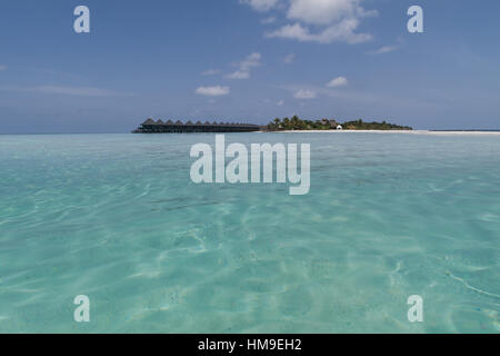 tropischen Malediven-Insel mit Palmen und Wasser Häuser von einer Sandbank im türkisfarbenen Wasser gesehen Stockfoto