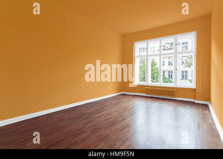 leeren Raum mit orangefarbenen Wänden und Holzboden Stockfoto