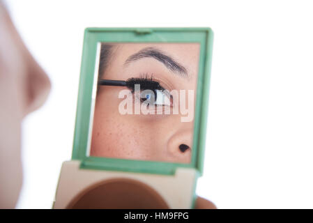 Reflexion der Augen des Mädchens während der Anwendung von mascara Stockfoto